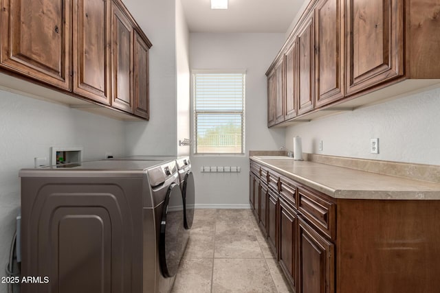washroom with cabinet space, washing machine and dryer, and baseboards