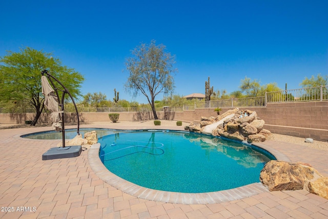 view of pool featuring a water slide, a fenced backyard, and a patio area