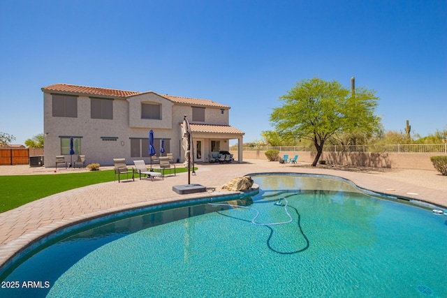 view of pool with a fenced backyard, a patio, and central AC unit