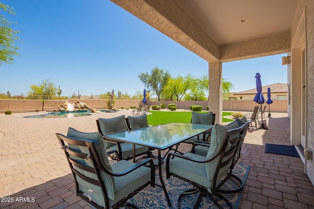 view of patio with outdoor dining area, a fenced backyard, and a pool with connected hot tub