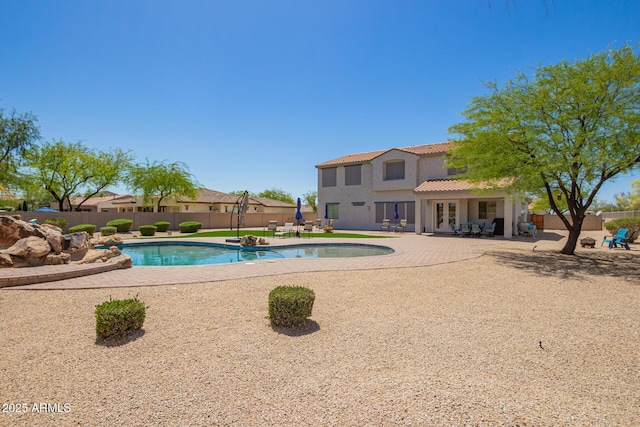 view of pool featuring a fenced backyard, a patio area, and french doors