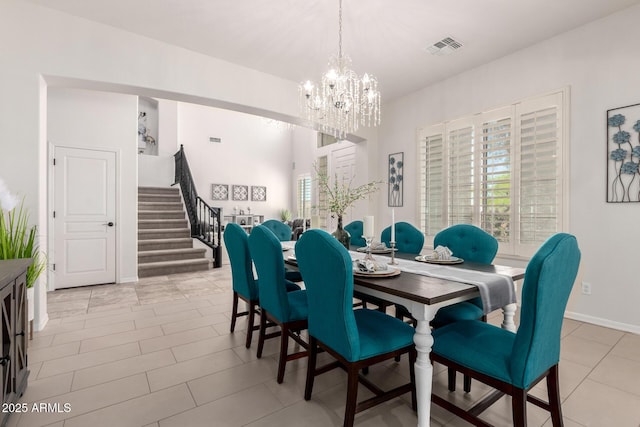 dining area featuring stairs, a chandelier, plenty of natural light, and baseboards