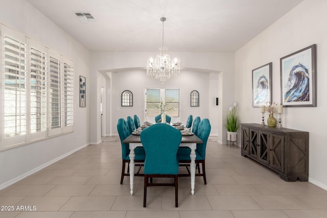 dining room with a chandelier, baseboards, and light tile patterned flooring