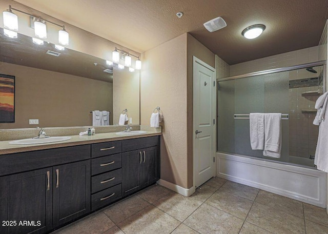 bathroom featuring tile patterned floors, vanity, bath / shower combo with glass door, and a textured ceiling