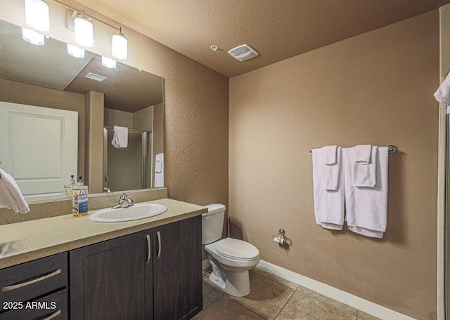 bathroom with tile patterned floors, vanity, toilet, and a textured ceiling