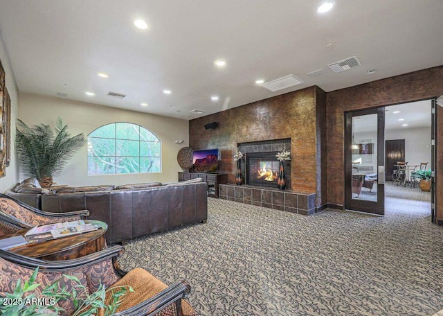 living room with carpet floors and a tiled fireplace