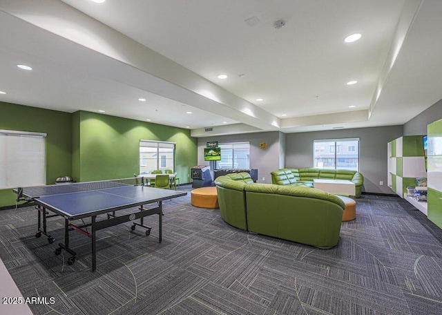 playroom featuring a tray ceiling and dark carpet