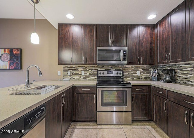 kitchen with tasteful backsplash, sink, stainless steel appliances, and decorative light fixtures