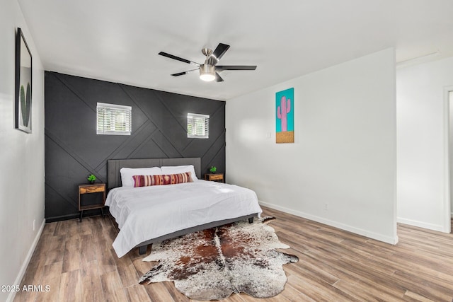 6628 N 2nd Ave, Phoenix, AZ 85013 - bedroom with baseboards, wood finished floors, an accent wall, and ceiling fan