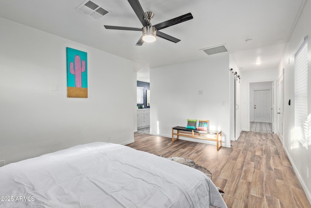 6628 N 2nd Ave, Phoenix, AZ 85013 - bedroom with wood finished floors, a barn door, baseboards, and ensuite bath