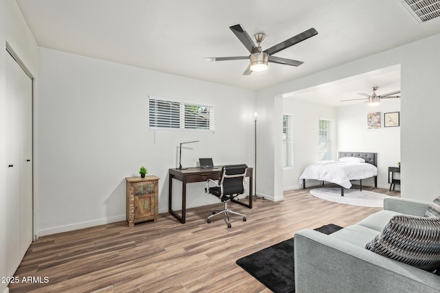 6628 N 2nd Ave, Phoenix, AZ 85013 - bedroom with a desk, wood finished floors, multiple windows, and baseboards