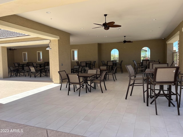 dining area featuring ceiling fan, a tray ceiling, and light tile patterned floors