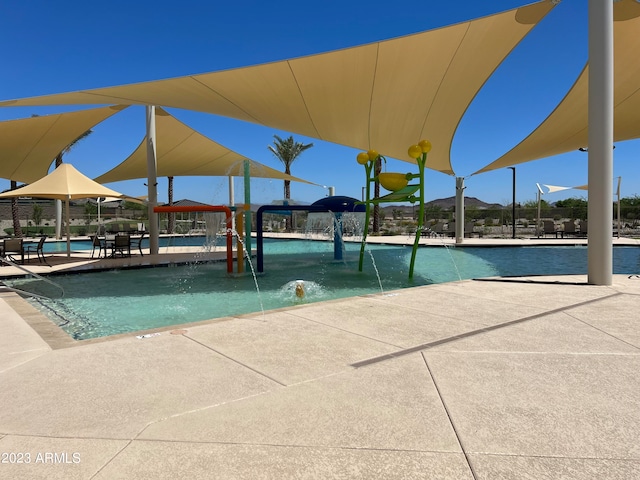 view of swimming pool with pool water feature and a patio