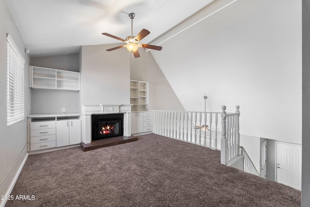 unfurnished living room with vaulted ceiling, ceiling fan, and dark carpet