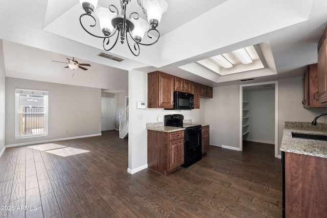 kitchen featuring dark wood-type flooring, a raised ceiling, sink, and black appliances