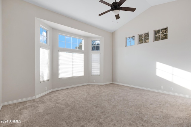 spare room with carpet floors, high vaulted ceiling, baseboards, and a ceiling fan