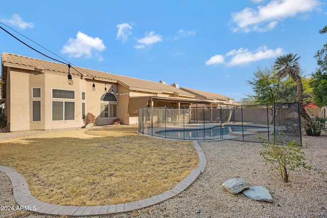 back of house with a fenced in pool