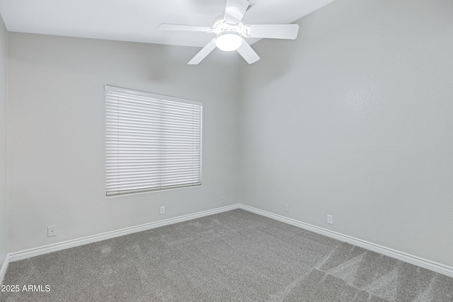 carpeted empty room featuring a ceiling fan and baseboards