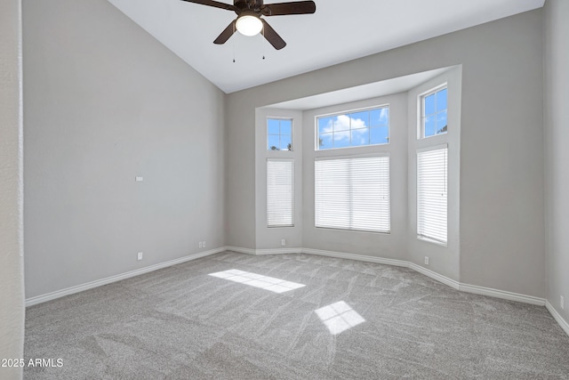 carpeted spare room featuring vaulted ceiling, a ceiling fan, and baseboards