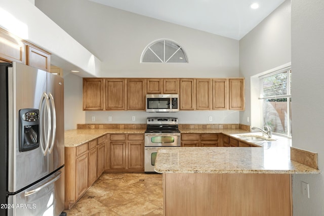 kitchen with high vaulted ceiling, sink, light stone countertops, kitchen peninsula, and stainless steel appliances