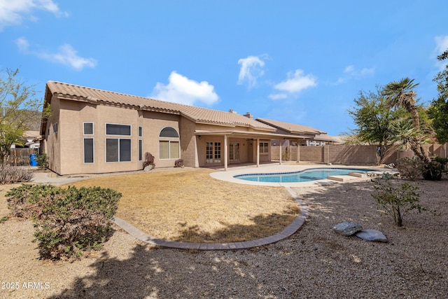 rear view of property with a fenced in pool, a patio area, a fenced backyard, and stucco siding