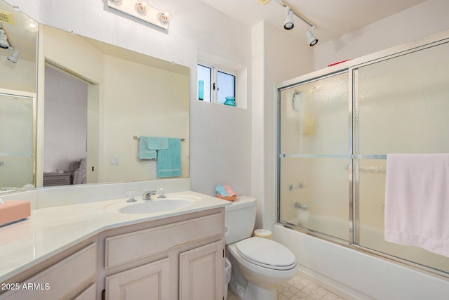 full bathroom featuring vanity, bath / shower combo with glass door, and toilet