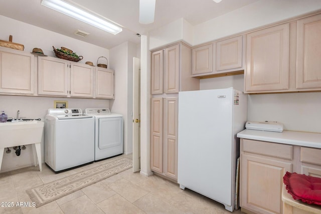 laundry room featuring cabinets, sink, light tile patterned floors, and washer and dryer