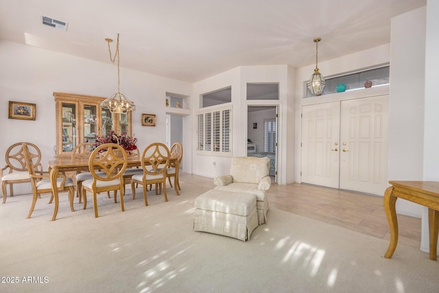 carpeted dining room with a chandelier