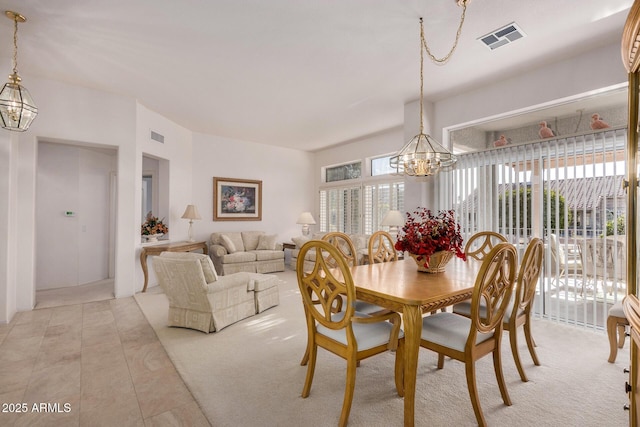 carpeted dining space with a notable chandelier