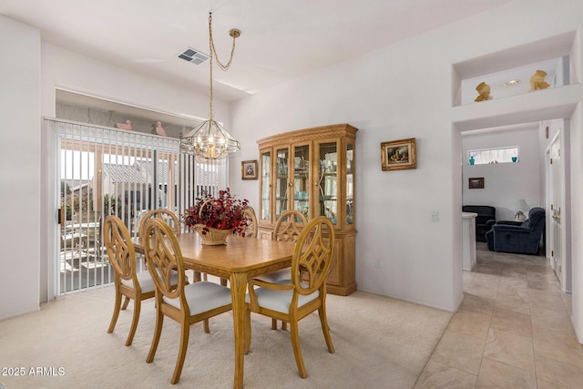 dining space featuring light tile patterned floors and an inviting chandelier