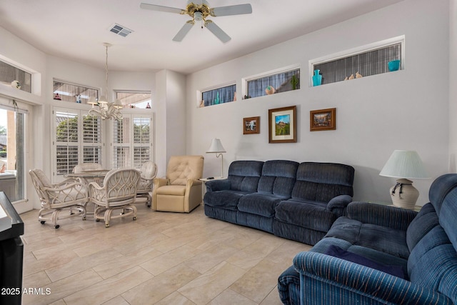 living room with ceiling fan with notable chandelier