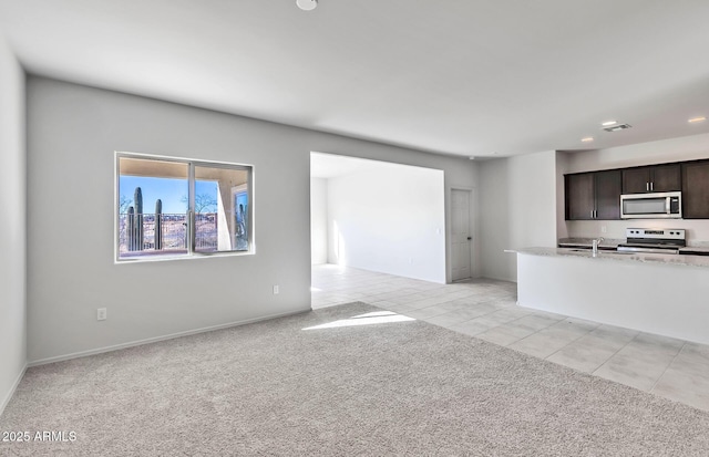 unfurnished living room featuring sink and light colored carpet