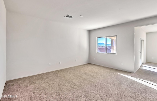 spare room featuring light carpet