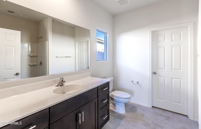 bathroom with tile patterned floors, vanity, toilet, and a shower with shower door