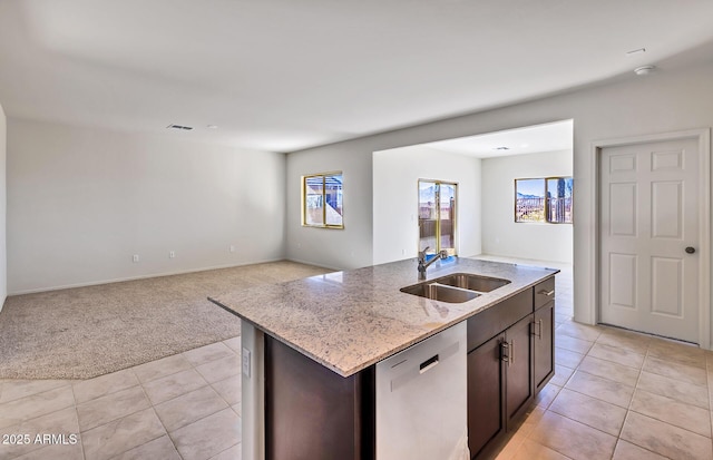 kitchen with an island with sink, dishwasher, sink, and dark brown cabinets