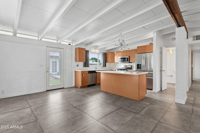 kitchen featuring a kitchen island, appliances with stainless steel finishes, brown cabinetry, light countertops, and vaulted ceiling with beams