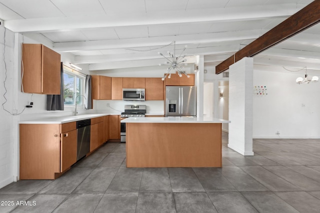 kitchen with a notable chandelier, a center island, appliances with stainless steel finishes, brown cabinetry, and light countertops