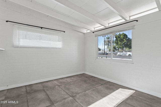 spare room featuring baseboards and vaulted ceiling with beams