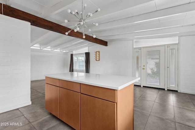 kitchen featuring an inviting chandelier, vaulted ceiling with beams, light countertops, and tile patterned floors