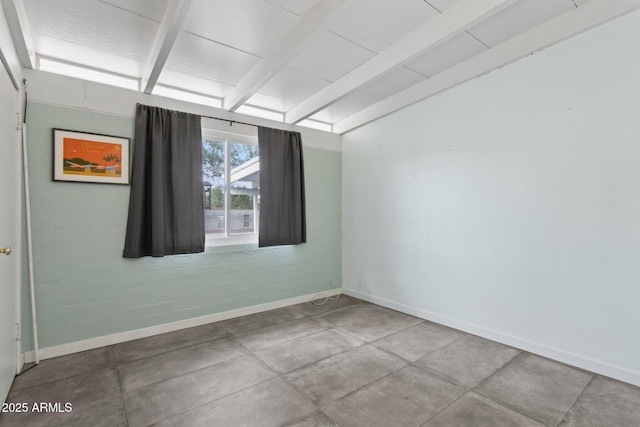 spare room featuring beam ceiling and baseboards