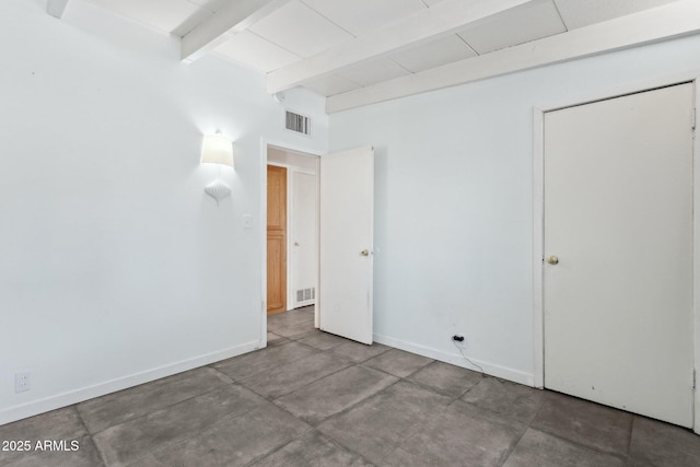 empty room featuring beam ceiling, baseboards, and visible vents