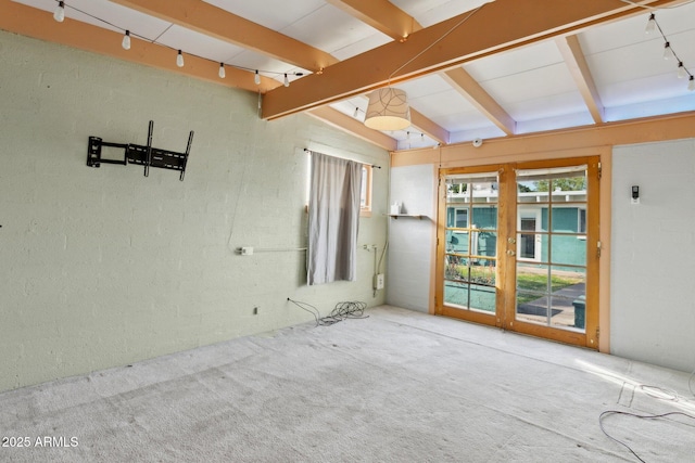 carpeted spare room featuring lofted ceiling with beams and rail lighting