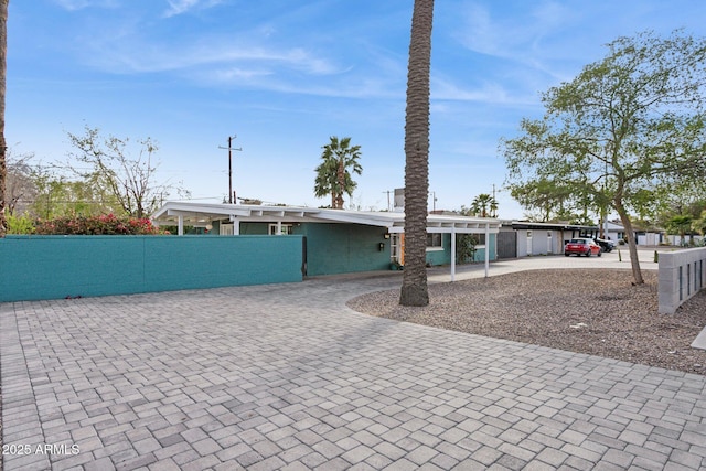 view of front of property with decorative driveway and fence