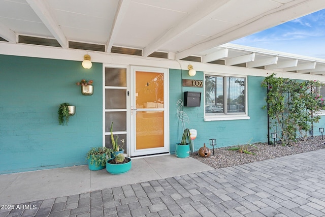 doorway to property featuring concrete block siding