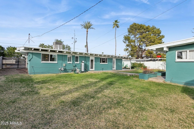 back of house with a lawn and fence