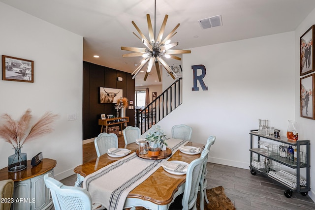 dining room featuring a ceiling fan, visible vents, wood finished floors, stairway, and baseboards