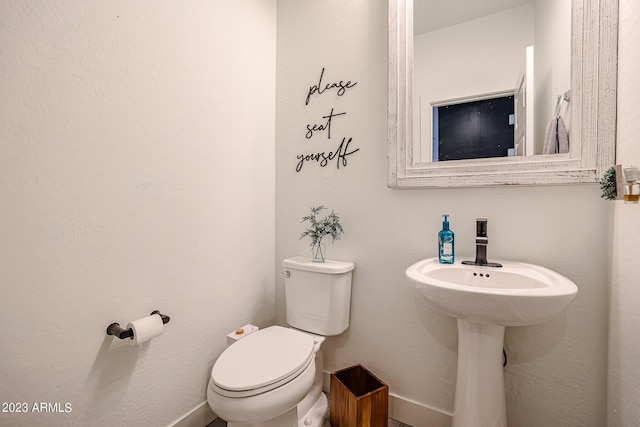 bathroom with baseboards and toilet
