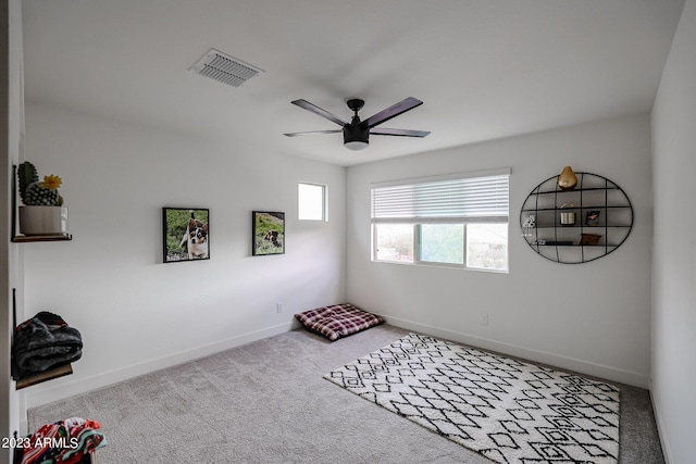 carpeted spare room with baseboards, a ceiling fan, and visible vents