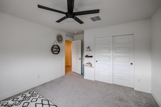 unfurnished bedroom with baseboards, visible vents, carpet, and a closet