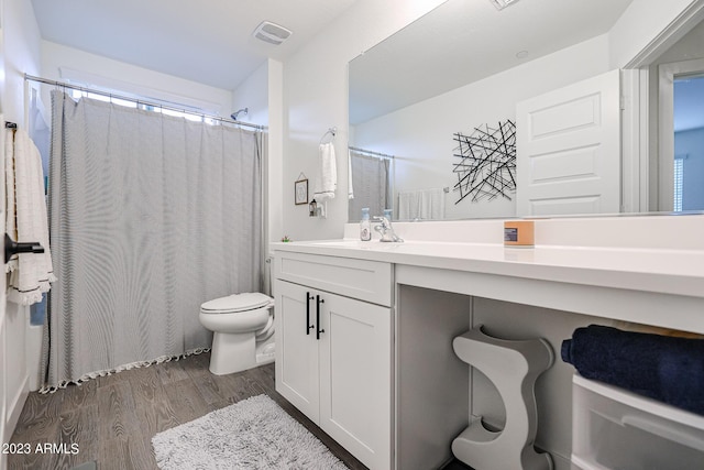 bathroom with visible vents, wood finished floors, vanity, toilet, and a shower with shower curtain